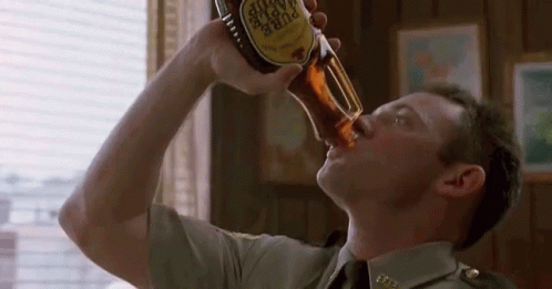 a man in a military uniform is drinking a bottle of pure taste