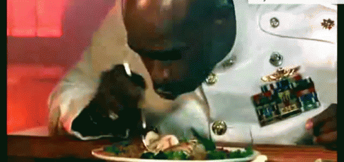 A Man In A Military Uniform Is Eating A Salad With A Fork . GIF
