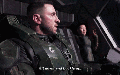 A Man In A Military Uniform Is Sitting Down And Buckle Up GIF
