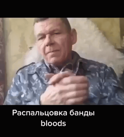 A Man In A Military Uniform Is Sitting In A Chair With His Hands Folded In Front Of Him . GIF