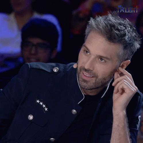 A Man In A Military Uniform Is Smiling And Talking On A Cell Phone In Front Of A Talent Logo GIF