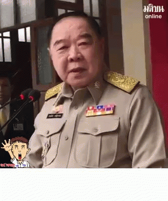 A Man In A Military Uniform Is Speaking Into A Microphone With A Cartoon Character Behind Him That Says Online On The Bo GIF