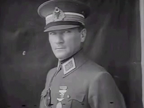 Man In Military Uniform In Front Of Black Wall GIF