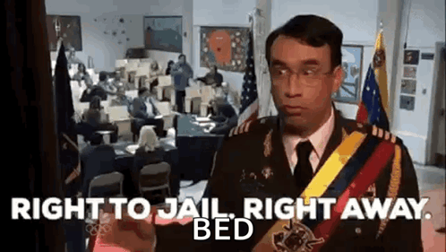 A Man In A Military Uniform Is Standing In Front Of A Group Of People In An Office . GIF