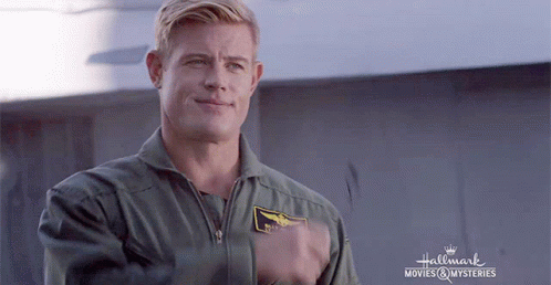 A Man In A Military Uniform Is Standing In Front Of A Sign That Says Hallmark Movies & Mysteries . GIF