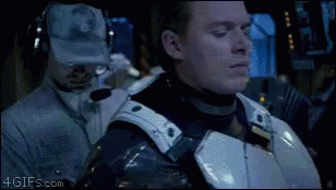 A Man In A Military Uniform Is Standing Next To Another Man Wearing Headphones And A Hat With A Military Logo On It GIF