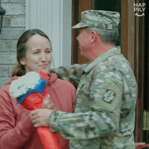 Man In Military Uniform Talking To Woman With Flowers GIF