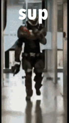 A Man In A Military Uniform Is Walking Down A Hallway With The Word Sup On It GIF