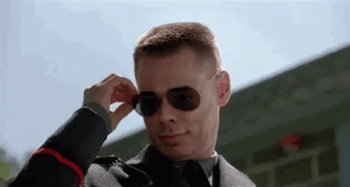 A Man In A Military Uniform Is Wearing Sunglasses And Adjusting His Sunglasses . GIF