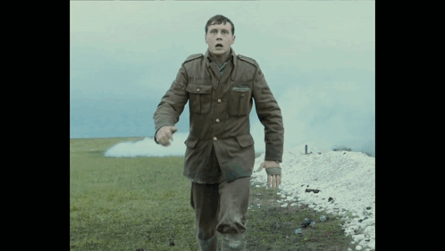 A Man In A Military Uniform Runs In A Field GIF