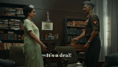 A Man In A Military Uniform Shakes Hands With A Woman In A Sari GIF