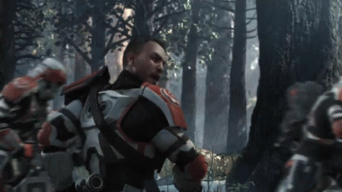 A Man In A Military Uniform Stands In A Forest GIF