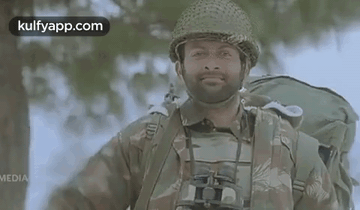 A Man In A Military Uniform With Binoculars And A Backpack Is Smiling . GIF