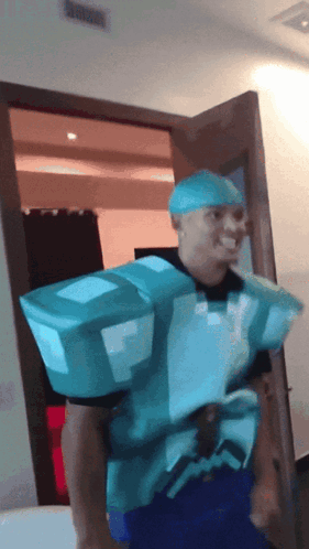 A Man In A Minecraft Costume Is Standing In A Room GIF