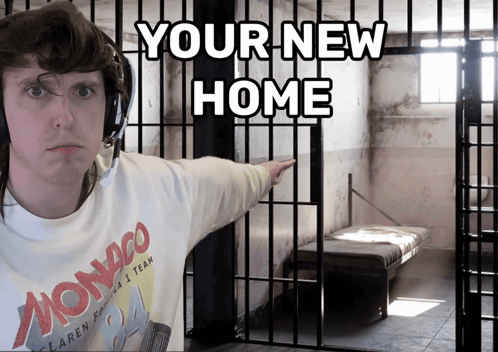 A Man In A Monaco Shirt Is Pointing To A Cell In A Jail Cell GIF