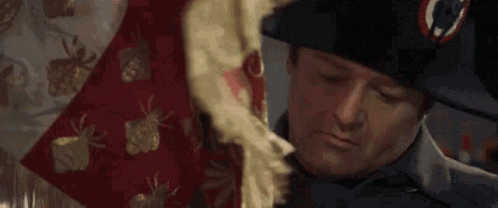 A Man In A Napoleon Hat Is Holding A Red And White Blanket . GIF