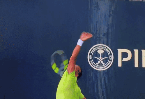 A Man In A Neon Green Shirt Is Playing Tennis GIF