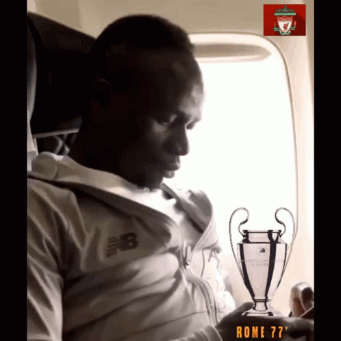 A Man In A New Balance Jacket Is Holding A Trophy GIF