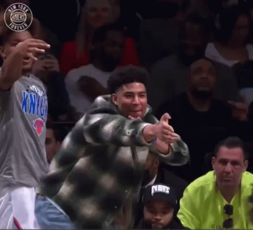 A Man In A New York Knicks Shirt Is Dancing In A Crowd GIF