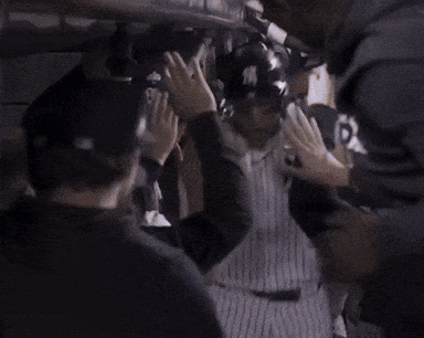 A Man In A New York Yankees Jersey Is Being Congratulated By His Teammates GIF