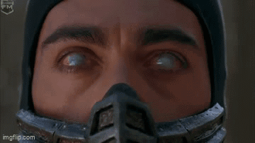 A Man In A Ninja Costume Is Standing In The Woods And Saying Come Here . GIF
