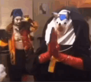 A Man In A Nun Costume Is Holding A Gun Next To A Woman In A Costume . GIF