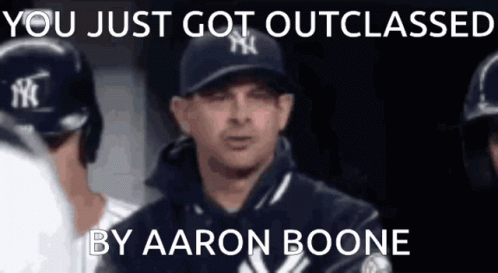 a man in a ny yankees hat is talking to his teammates