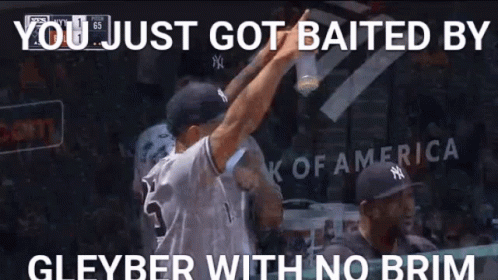 A Man In A Ny Yankees Jersey Is Holding A Bottle Of Beer While Standing In A Dugout . GIF