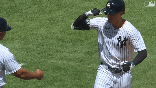 A Man In A Ny Yankees Uniform Is Giving A Fist Bump To Another Man GIF