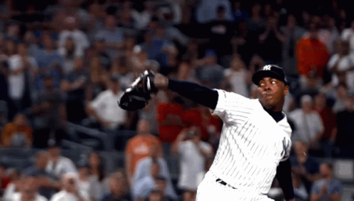 A Man In A Ny Yankees Uniform Throws A Ball GIF