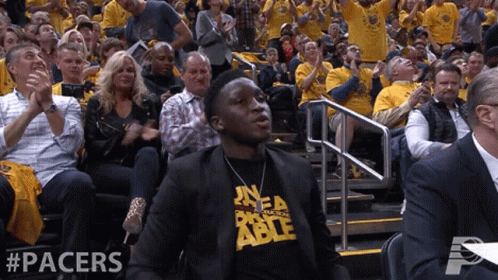 A Man In A Pacers Shirt Sits In The Stands Watching A Game GIF