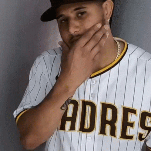 A Man In A Padres Jersey Covering His Mouth GIF