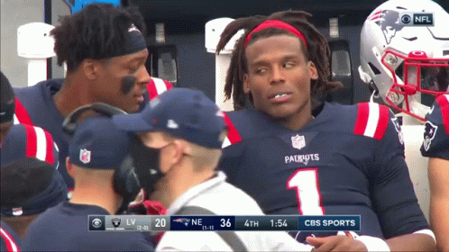 A Man In A Patriots Jersey Is Sitting On The Bench GIF