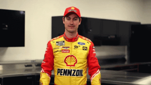 A Man In A Pennzoil Jacket Stands In A Room GIF
