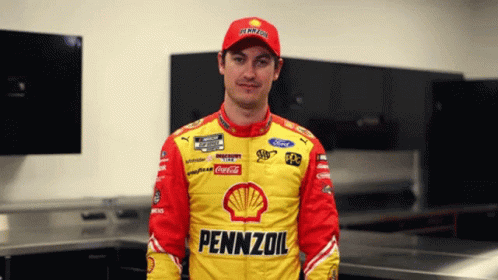 A Man In A Pennzoil Jacket Stands In A Room GIF
