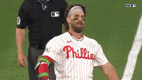 a man in a phillies jersey stands on a field