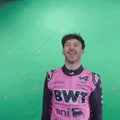 A Man In A Pink And Black Racing Suit Is Laughing And Smiling . GIF