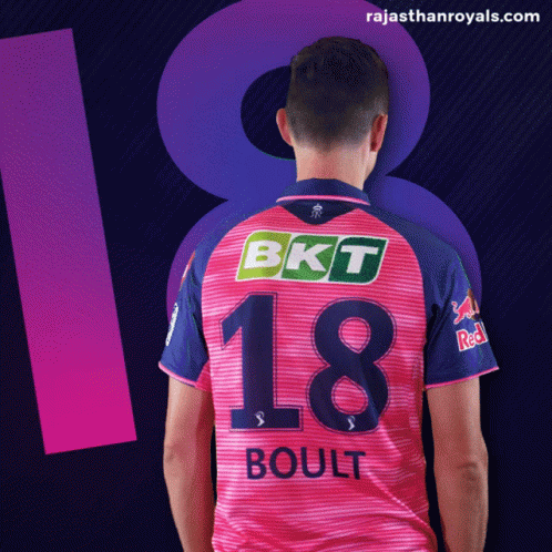 a man in a pink and blue jersey with the number 18 on it
