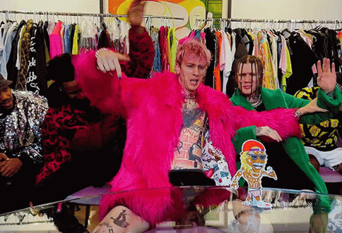 A Man In A Pink Fur Coat Is Sitting On A Table With Other People GIF