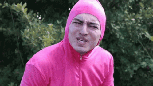 A Man In A Pink Hoodie Is Making A Face GIF