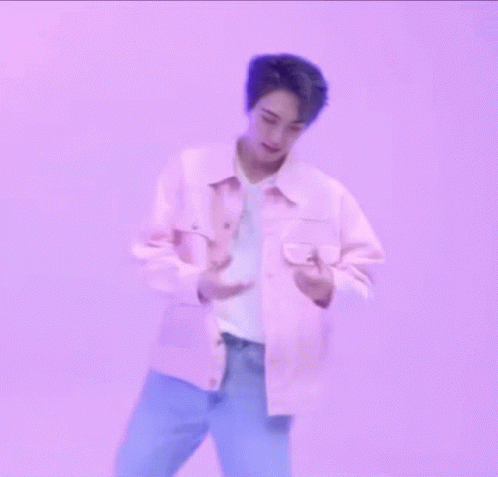 A Man In A Pink Jacket Is Making A Heart With His Hands GIF