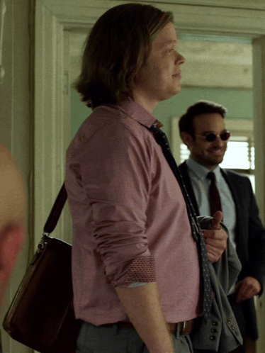 A Man In A Pink Shirt And Tie Is Standing Next To Another Man GIF
