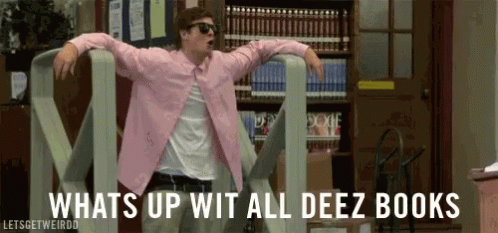 A Man In A Pink Shirt Is Dancing In A Library With The Words Whats Up Wit All Deez Books Behind Him . GIF