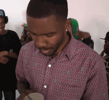 A Man In A Pink Shirt Is Standing In A Crowd Of People . GIF