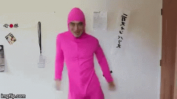 A Man In A Pink Suit Is Dancing In Front Of A Wall . GIF