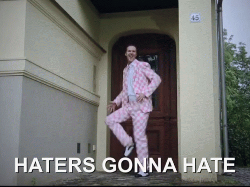 A Man In A Pink Suit Is Jumping In Front Of A Door That Says 45 On It GIF