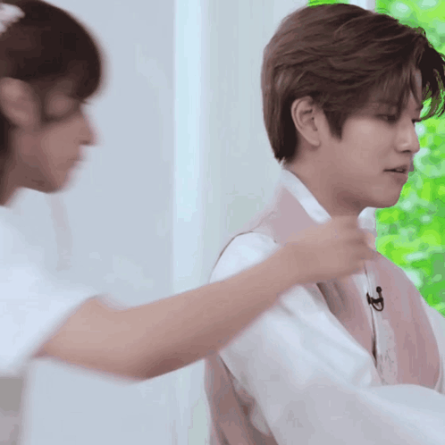 A Man In A Pink Vest Is Being Helped By A Woman In White GIF