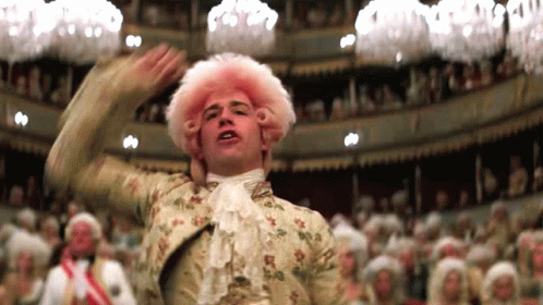 A Man In A Pink Wig Is Dancing In A Theater GIF