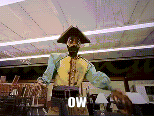 A Man In A Pirate Costume Is Standing In A Room With The Word Ow Written On The Screen Behind Him GIF