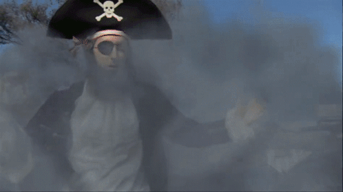 A Man In A Pirate Costume Is Standing In Front Of A Sign For Nickelodeon GIF